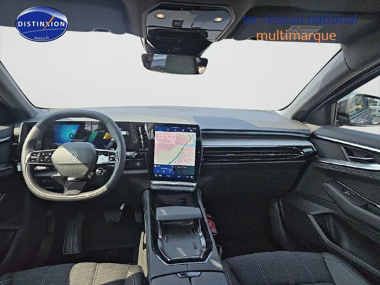 Intérieur avant du Renault Austral gris schiste 2025, tableau de bord moderne avec écran tactile vertical et volant multifonction.