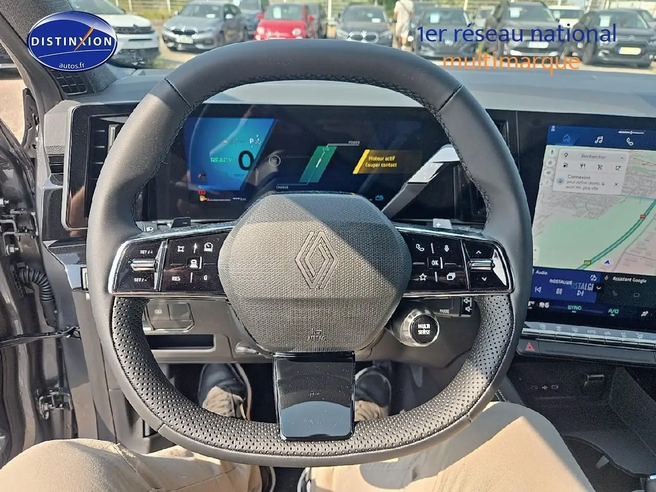Vue intérieure centrée sur le volant multifonction noir du Renault Austral gris schiste avec écrans numériques en arrière-plan.