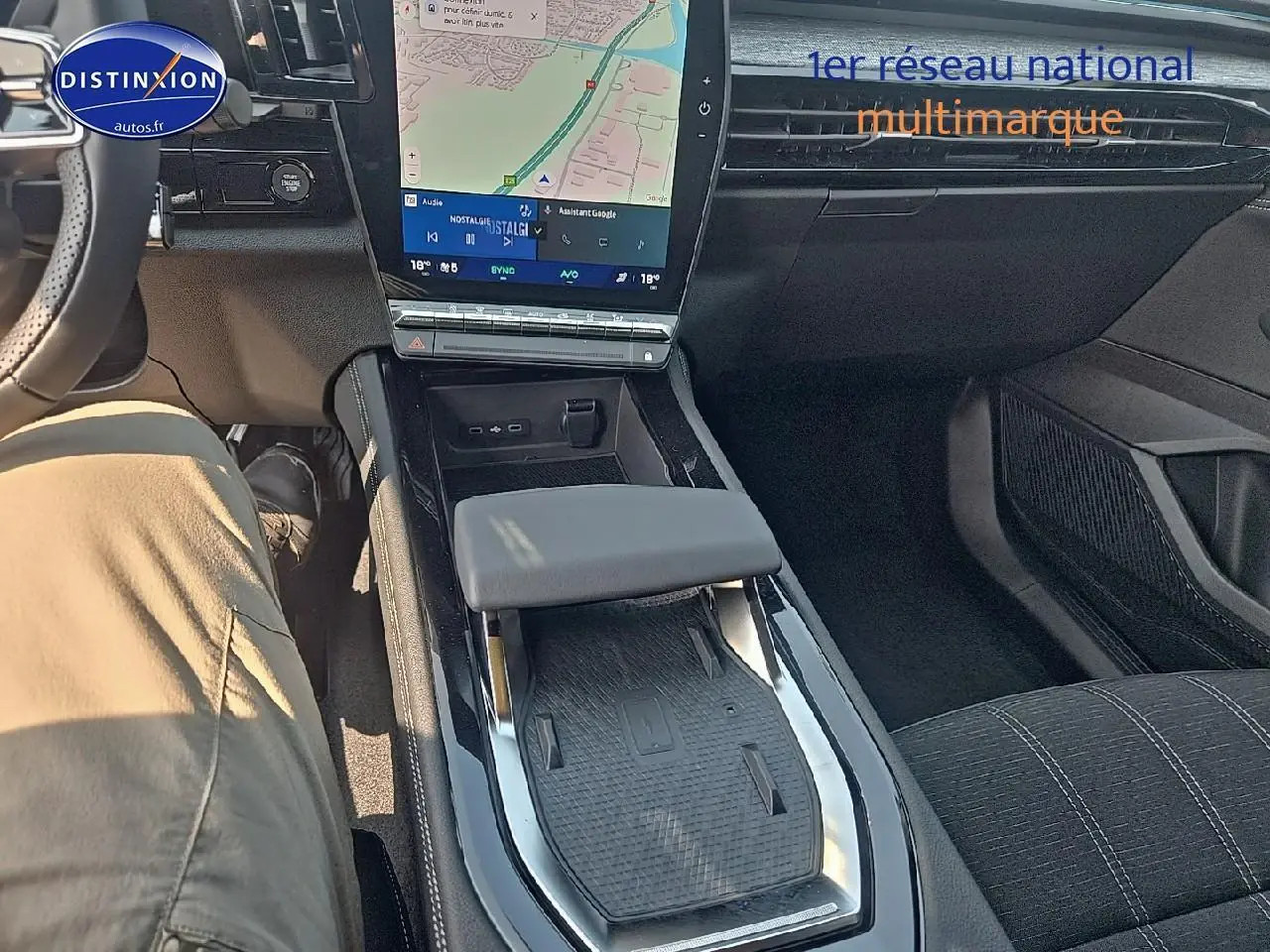 Intérieur du Renault Austral 2025 en gris, vue centrée sur la console centrale avec écran tactile et accoudoir.