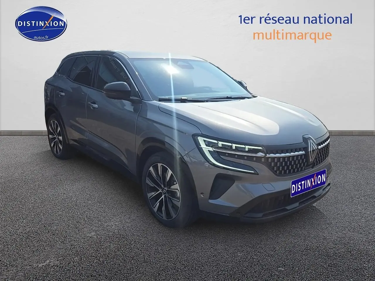 Renault Austral gris schiste en 3/4 avant droit avec jantes alu et phares LED allumés sur fond neutre.