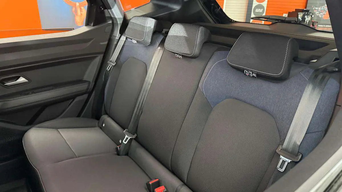 Vue intérieure de la banquette arrière du Dacia Duster noir nacré 2026, avec ceintures et appuie-têtes visibles.