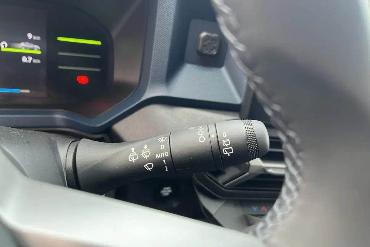 Gros plan sur la commande d’essuie-glace côté gauche du tableau de bord du Dacia Duster noir nacré 2026.