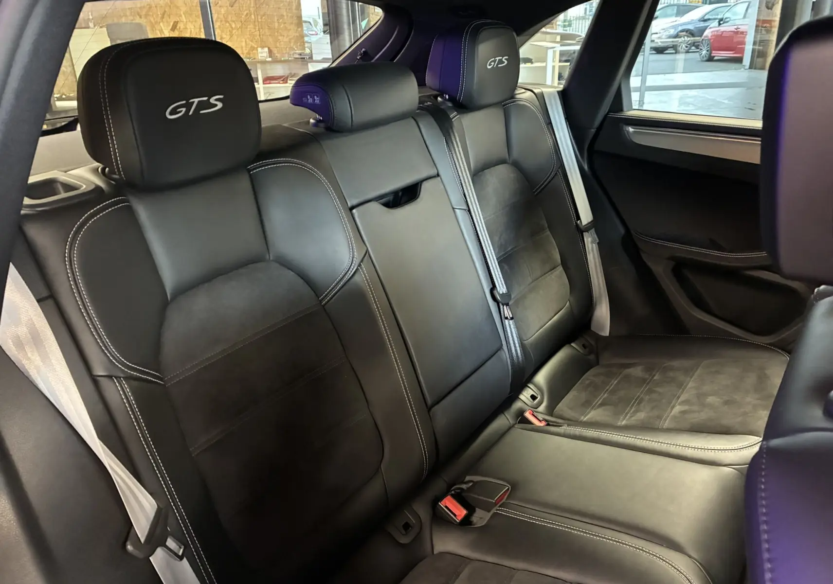 Vue intérieure des sièges arrière noirs en cuir et alcantara du Porsche Macan GTS avec appuis-tête brodés GTS.