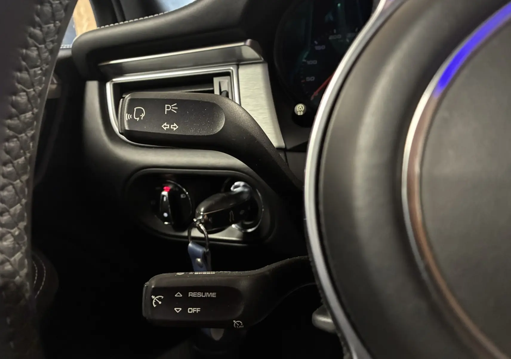 Gros plan sur les commandes au volant noir du Porsche Macan GTS 2017, montrant les leviers de clignotants et régulateur de vitesse.