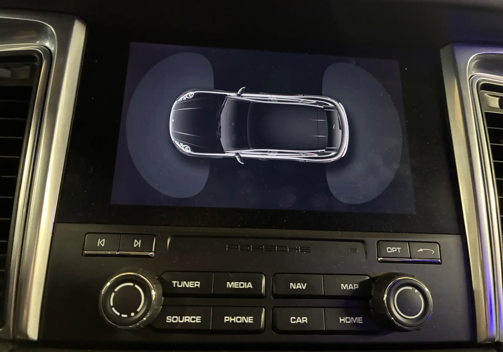 Vue de dessus numérique d'une Porsche Macan GTS noire affichée sur l'écran central du tableau de bord.