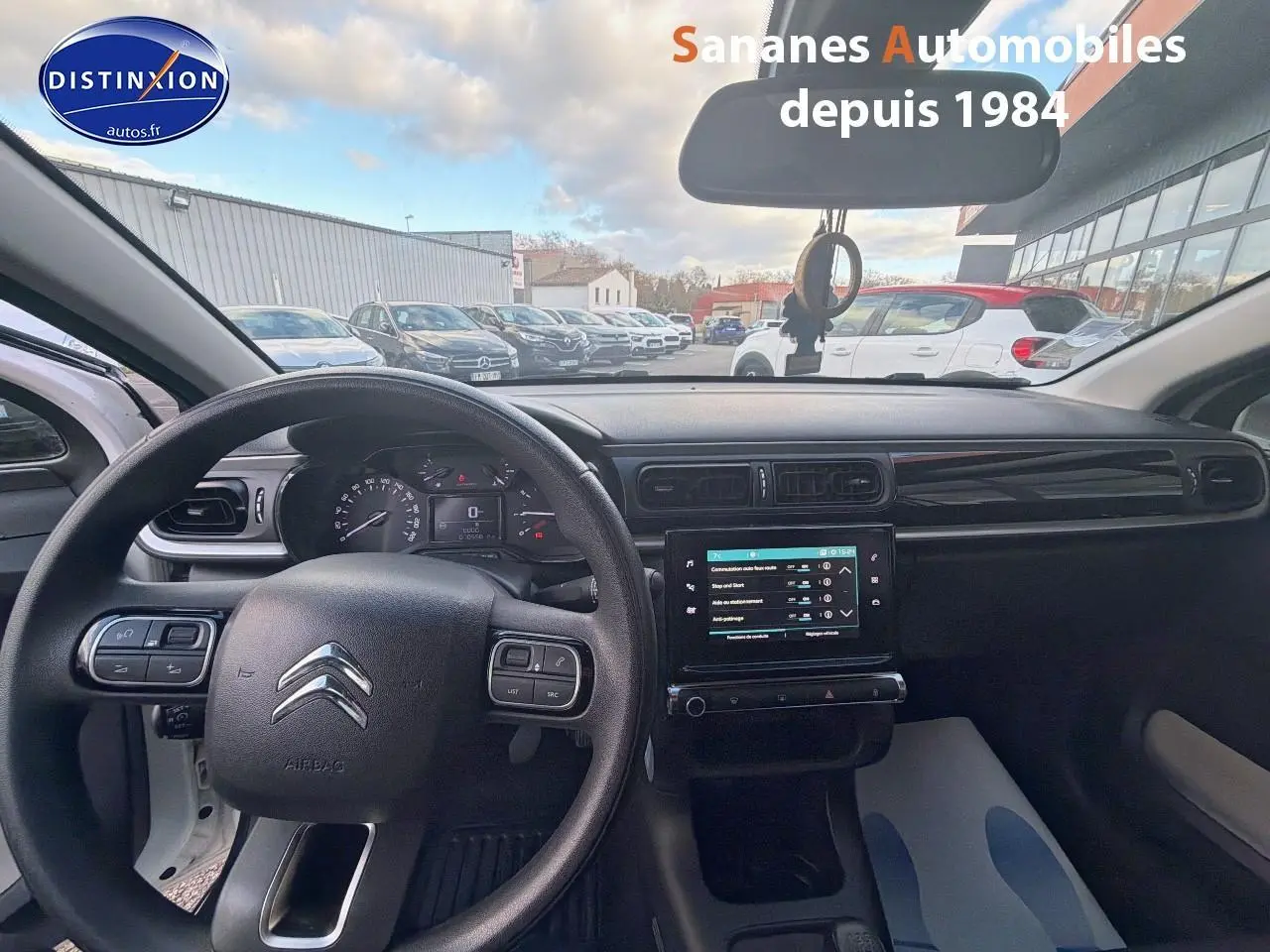 Vue intérieure avant du tableau de bord de la Citroën C3 blanche, avec volant et écran tactile central allumé.