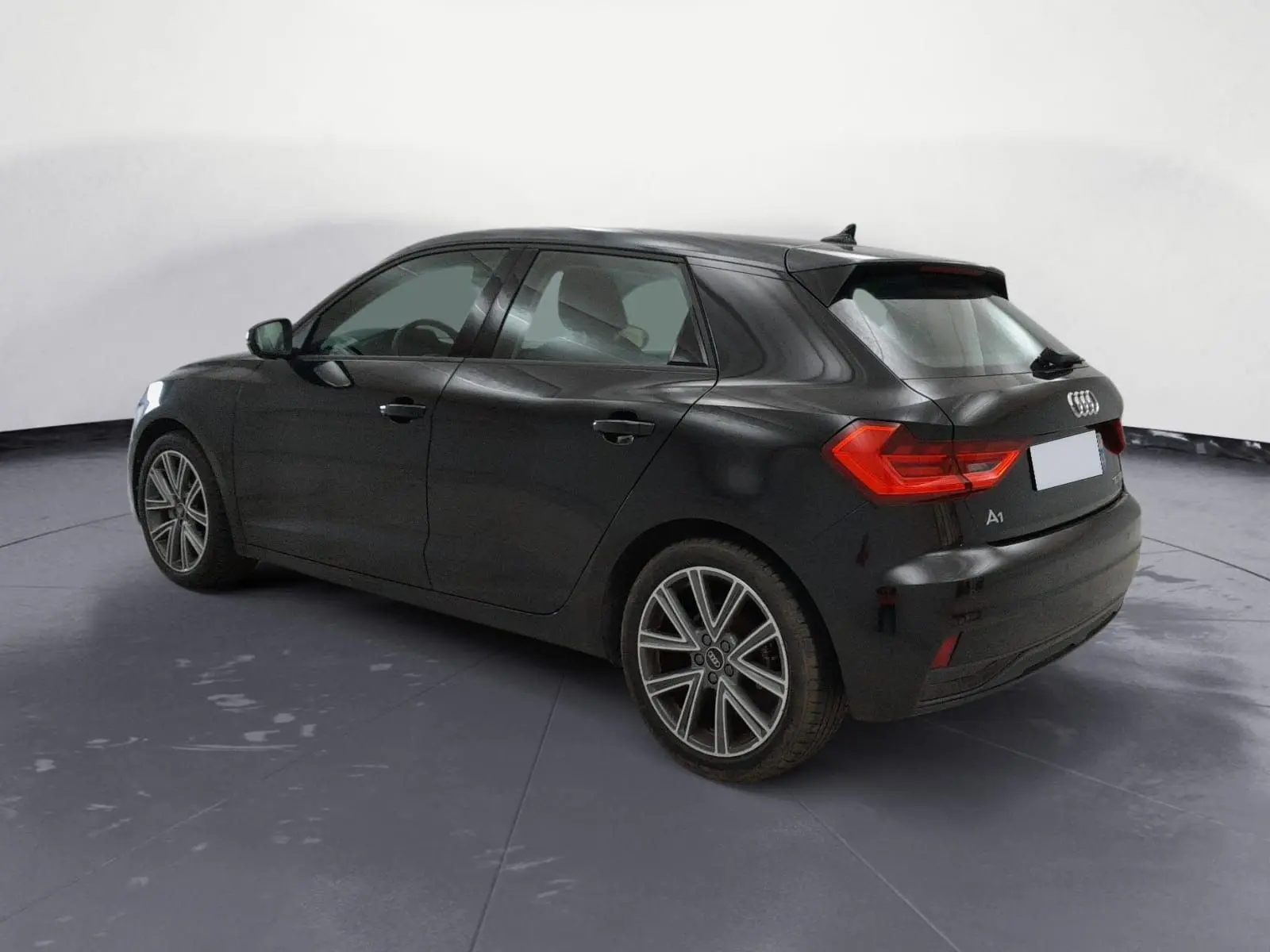 Audi A1 Sportback noir vue 3/4 arrière côté gauche, avec feux arrière LED et jantes alliage distinctives.