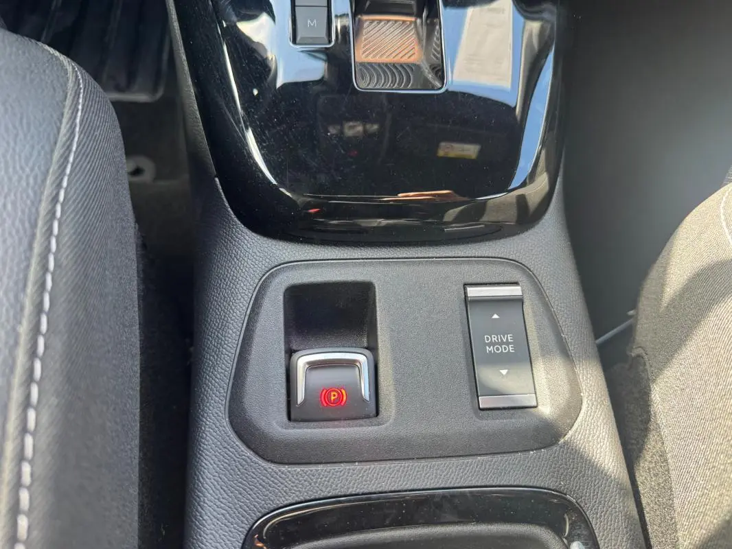 Gros plan sur la console centrale noire de l’Opel Corsa 2025, avec bouton frein à main électrique et commande Drive Mode.