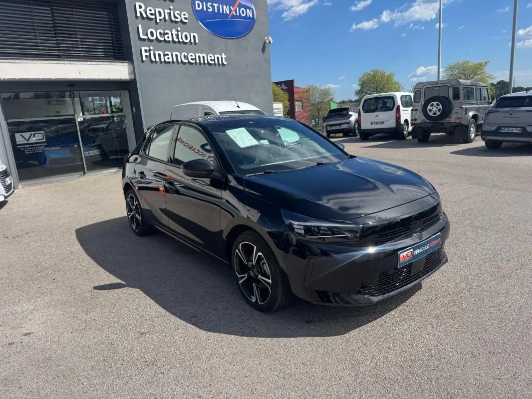 Opel Corsa noire vue 3/4 avant droit, jantes alliage 17 pouces, stationnée devant un concessionnaire.