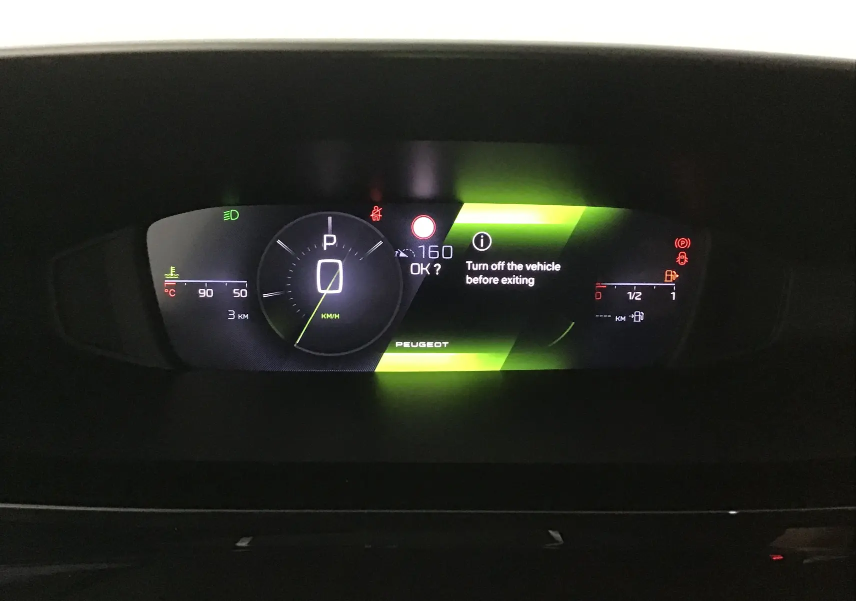 Affichage numérique du tableau de bord de la Peugeot 308 2025, indiquant la vitesse à zéro et des alertes en vert et rouge.