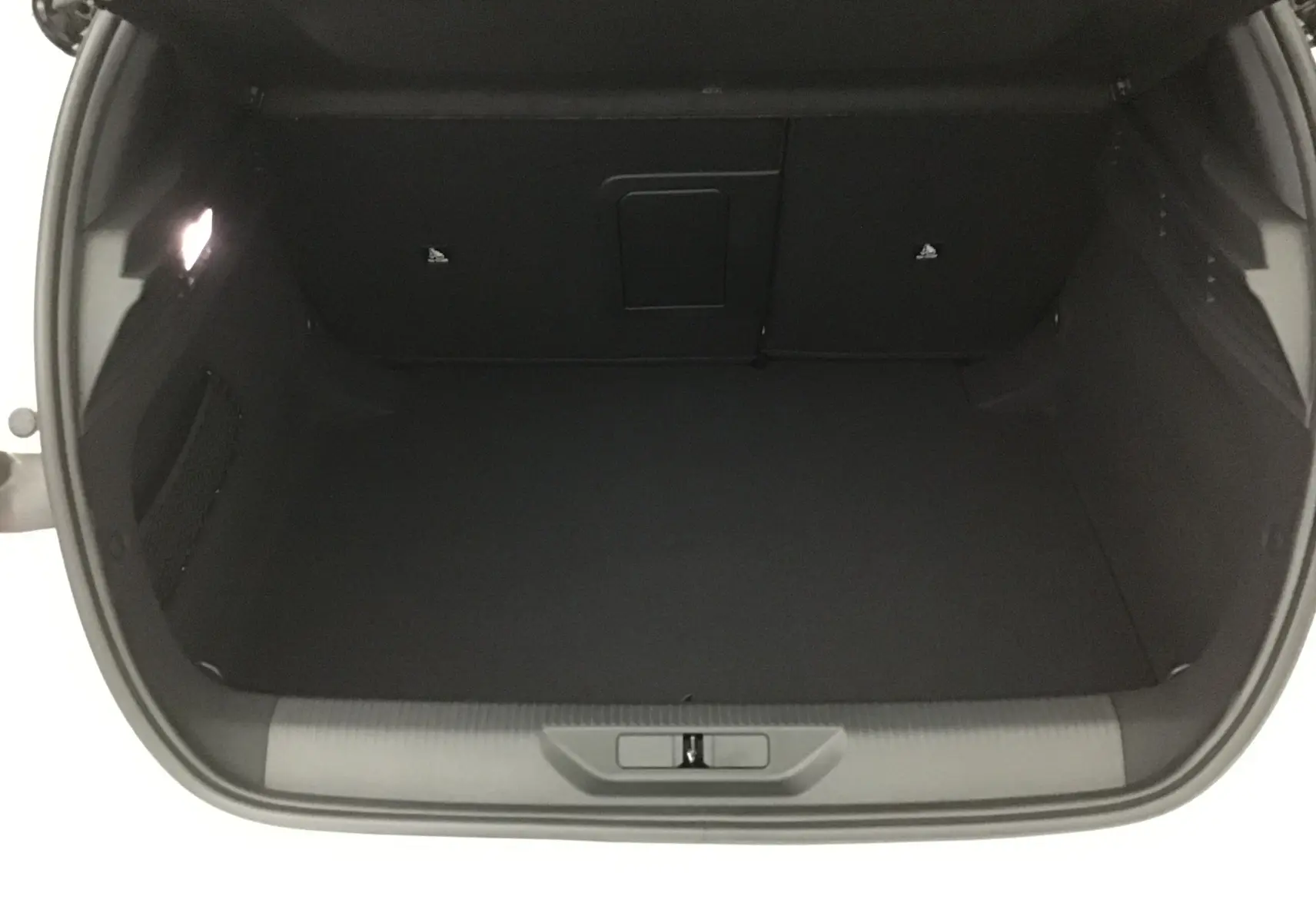 Coffre ouvert de la Peugeot 308 GT+Pack Alcantara blanc Okenite, vue intérieure spacieuse et bien éclairée.