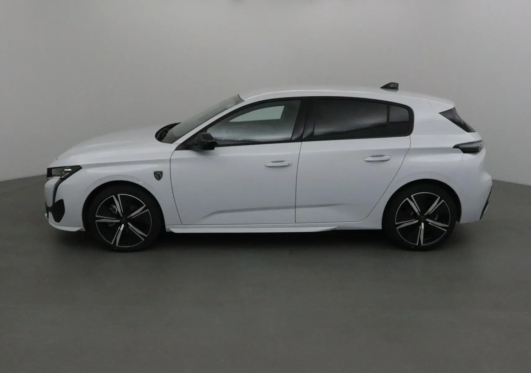 Peugeot 308 blanche vue de profil côté gauche, avec jantes noires et détails noirs contrastants.