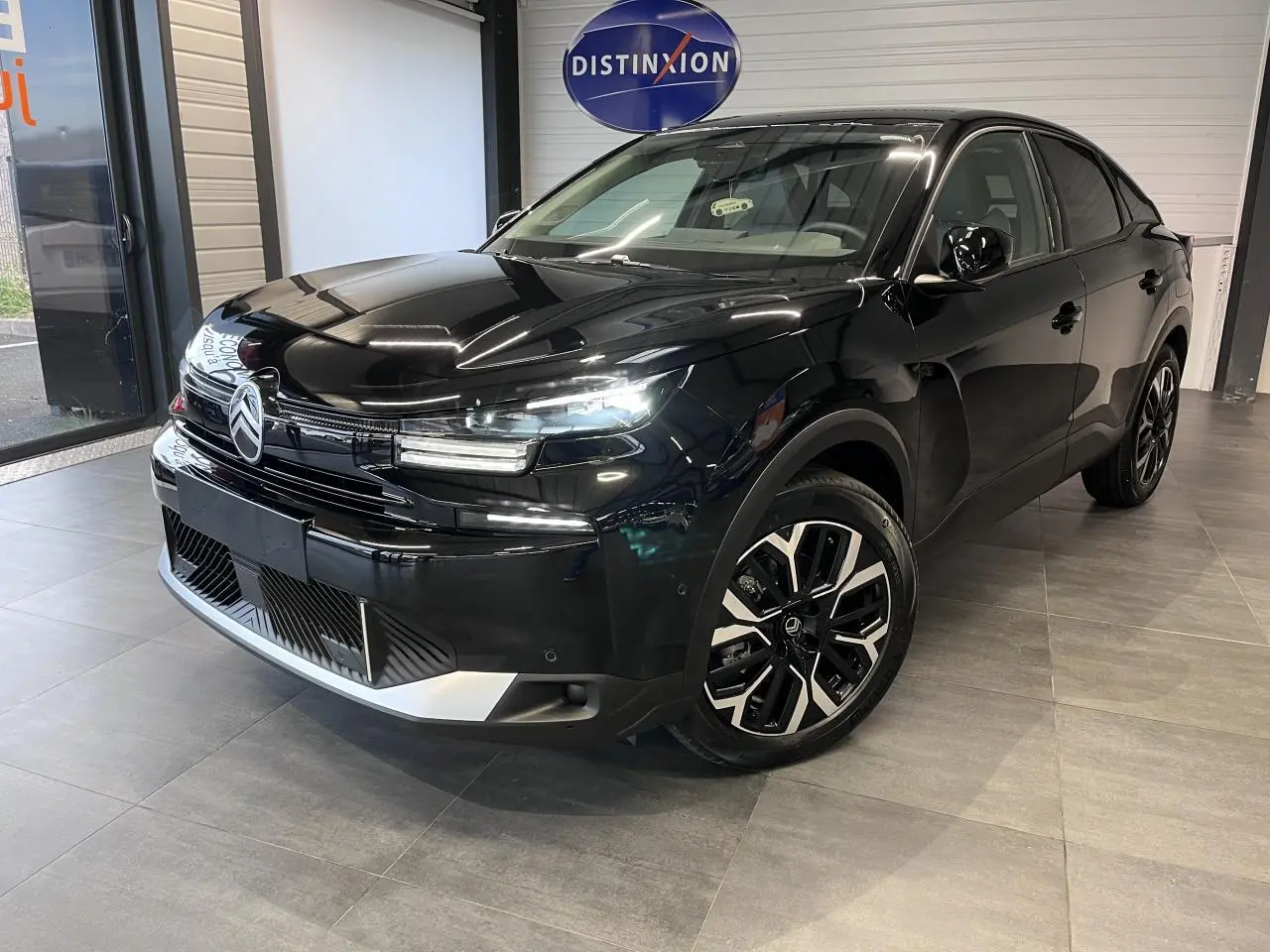 Citroën C4 2025 noir métal vue 3/4 avant droit avec jantes alliage diamantées et calandre moderne.