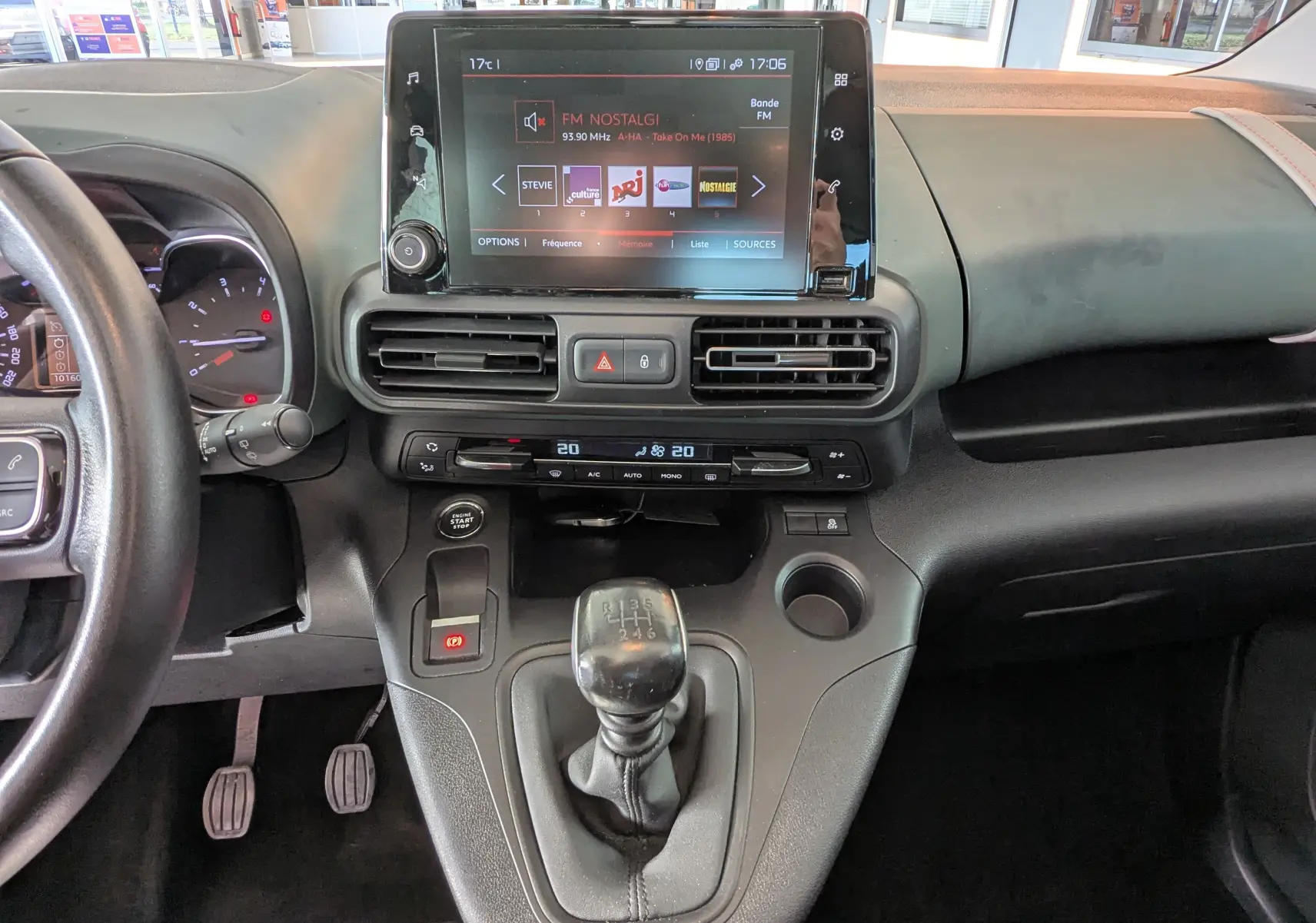 Vue intérieure centrée sur la console centrale et levier de vitesse manuelle du Citroën Berlingo beige de 2019.