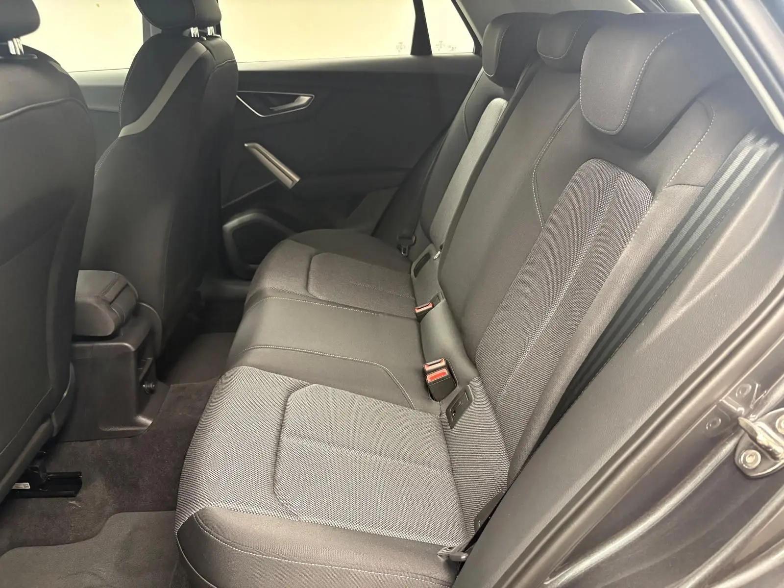 Vue latérale droite de la banquette arrière en tissu gris de l'Audi Q2 35 TFSI S Line, intérieur sobre et moderne.