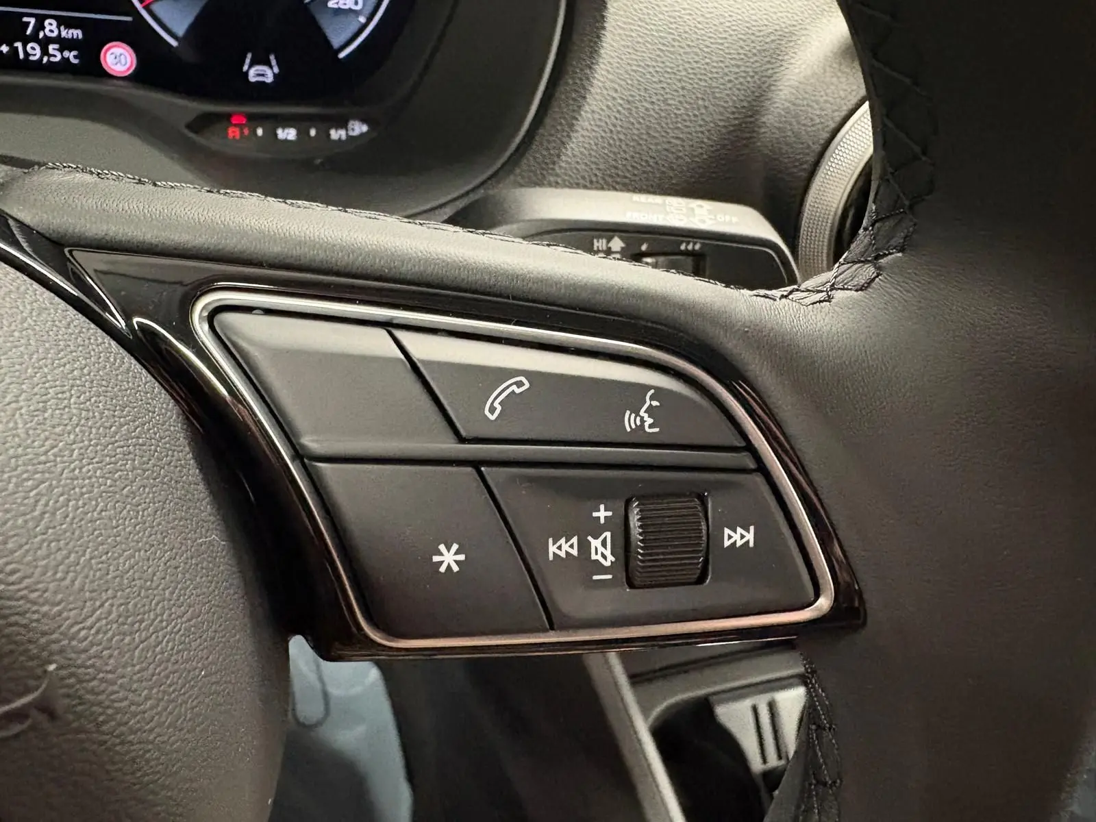 Gros plan sur les commandes au volant noir de l'Audi Q2 35 TFSI S Line 2026 en Gris Daytona.