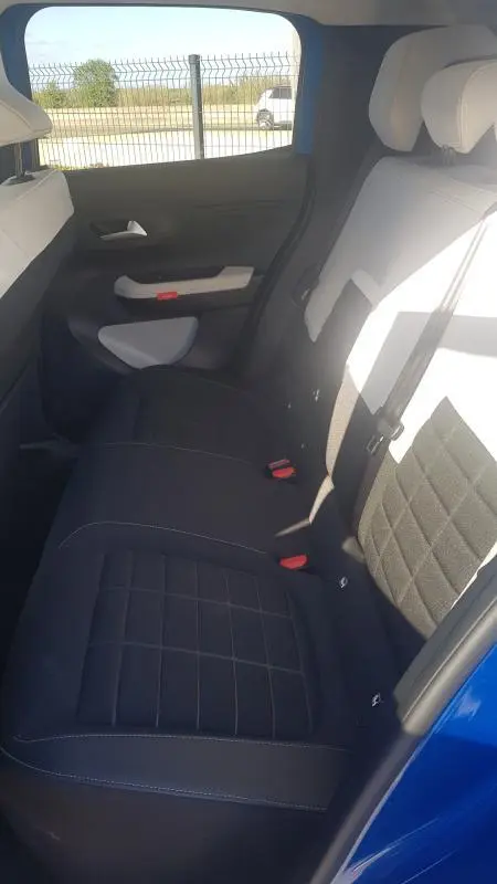 Vue intérieure côté droit des sièges arrière noirs de la Citroën C3 bleu foncé 2024, avec ceinture de sécurité visible.