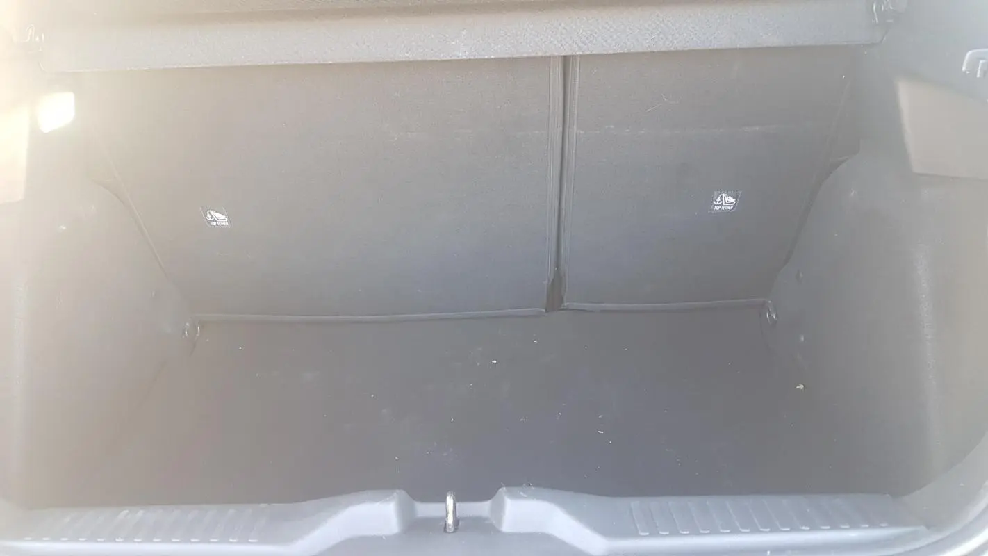 Coffre ouvert vu de face d'une Citroën C3 2024 bleu foncé, montrant l'espace de chargement vide.