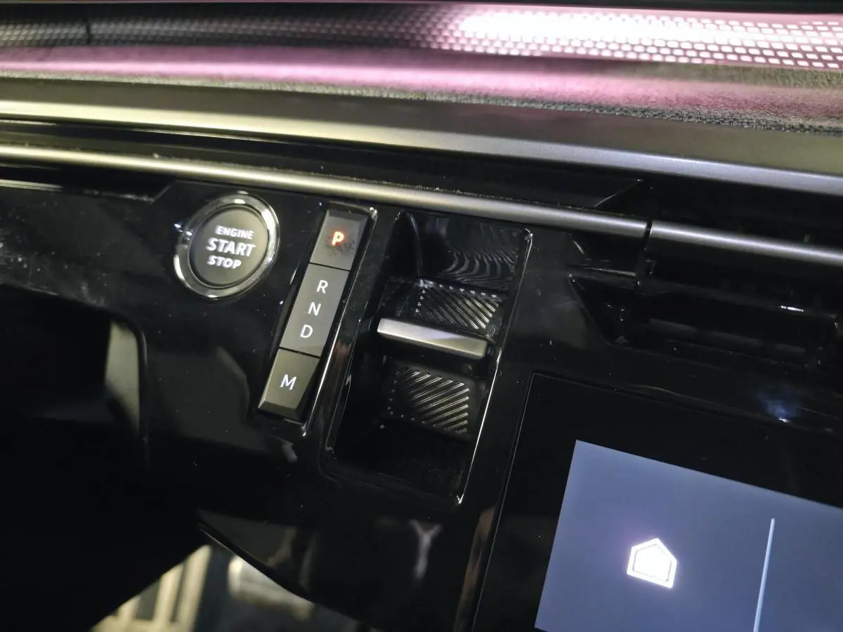 Détail de la console centrale noire brillante du Peugeot 3008 2025 avec bouton start/stop et commandes de boîte auto.