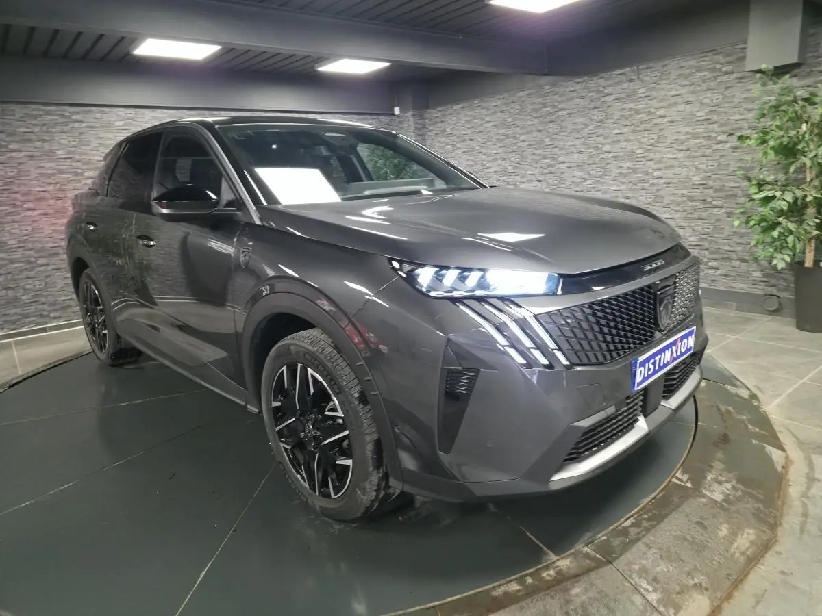 Peugeot 3008 gris métallisé vue 3/4 avant droit, avec phares LED allumés et jantes alliage noires.