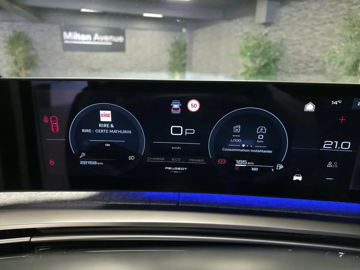 Tableau de bord numérique du Peugeot 3008 hybride 2025 avec affichage connecté et éclairage d’ambiance bleu.