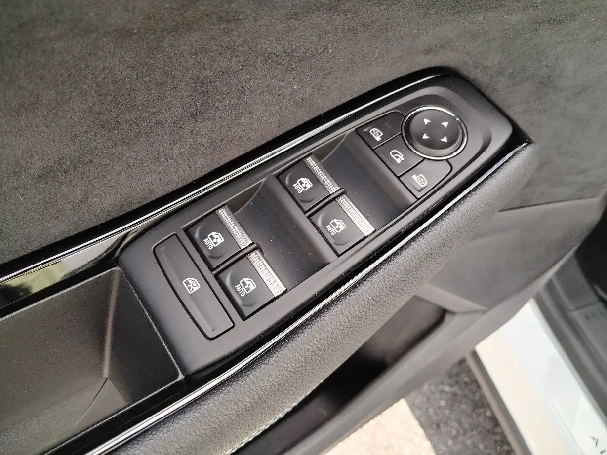 Gros plan sur les commandes des vitres et rétroviseurs côté conducteur du Renault Austral blanc nacré toit noir.