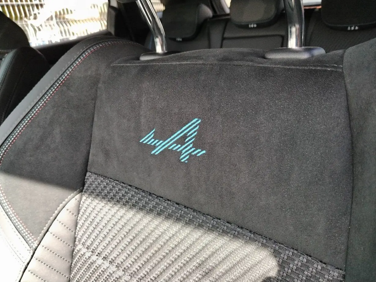 Gros plan sur le dossier de siège avant noir avec broderie bleue Esprit Alpine dans un Renault Austral 2025.