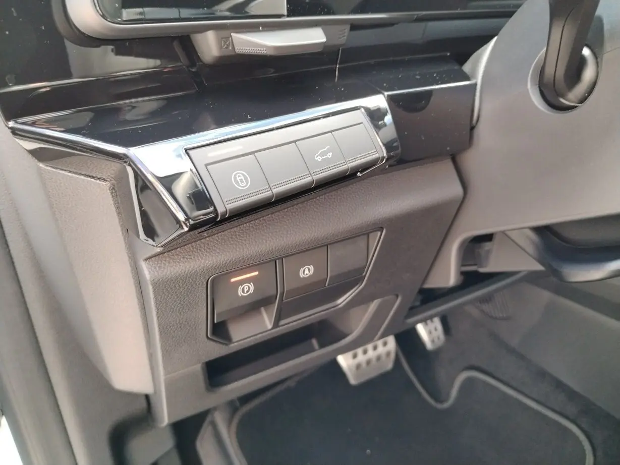 Gros plan sur les commandes noires du tableau de bord côté gauche du Renault Austral blanc nacré 2025 Esprit Alpine.