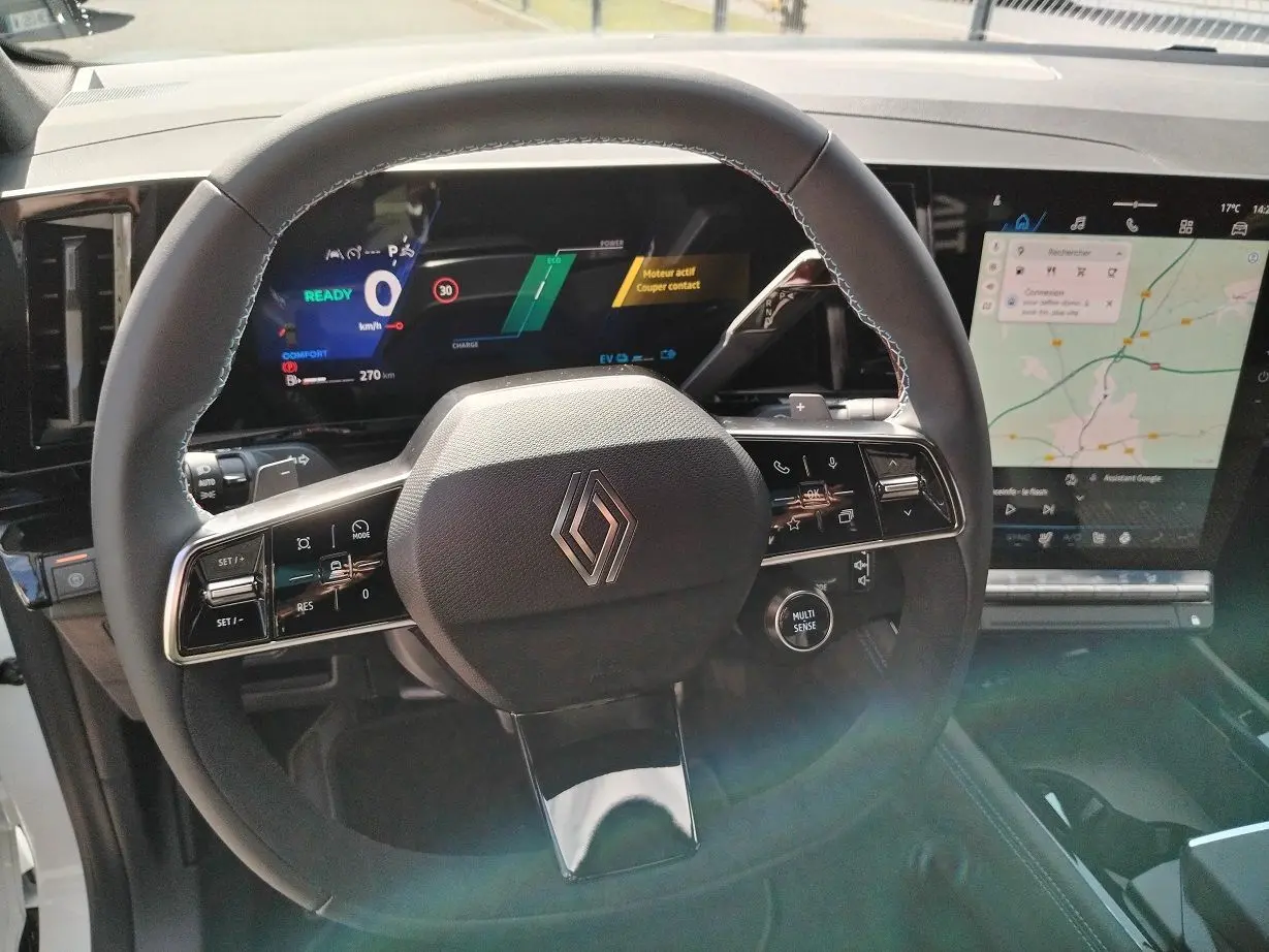 Vue rapprochée du volant noir du Renault Austral E-Tech avec tableau de bord numérique et écran tactile de navigation.
