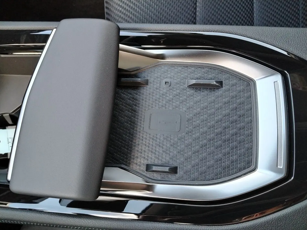 Gros plan sur la console centrale noire et argentée du Renault Austral E-Tech 2025 avec repose-bras rembourré.