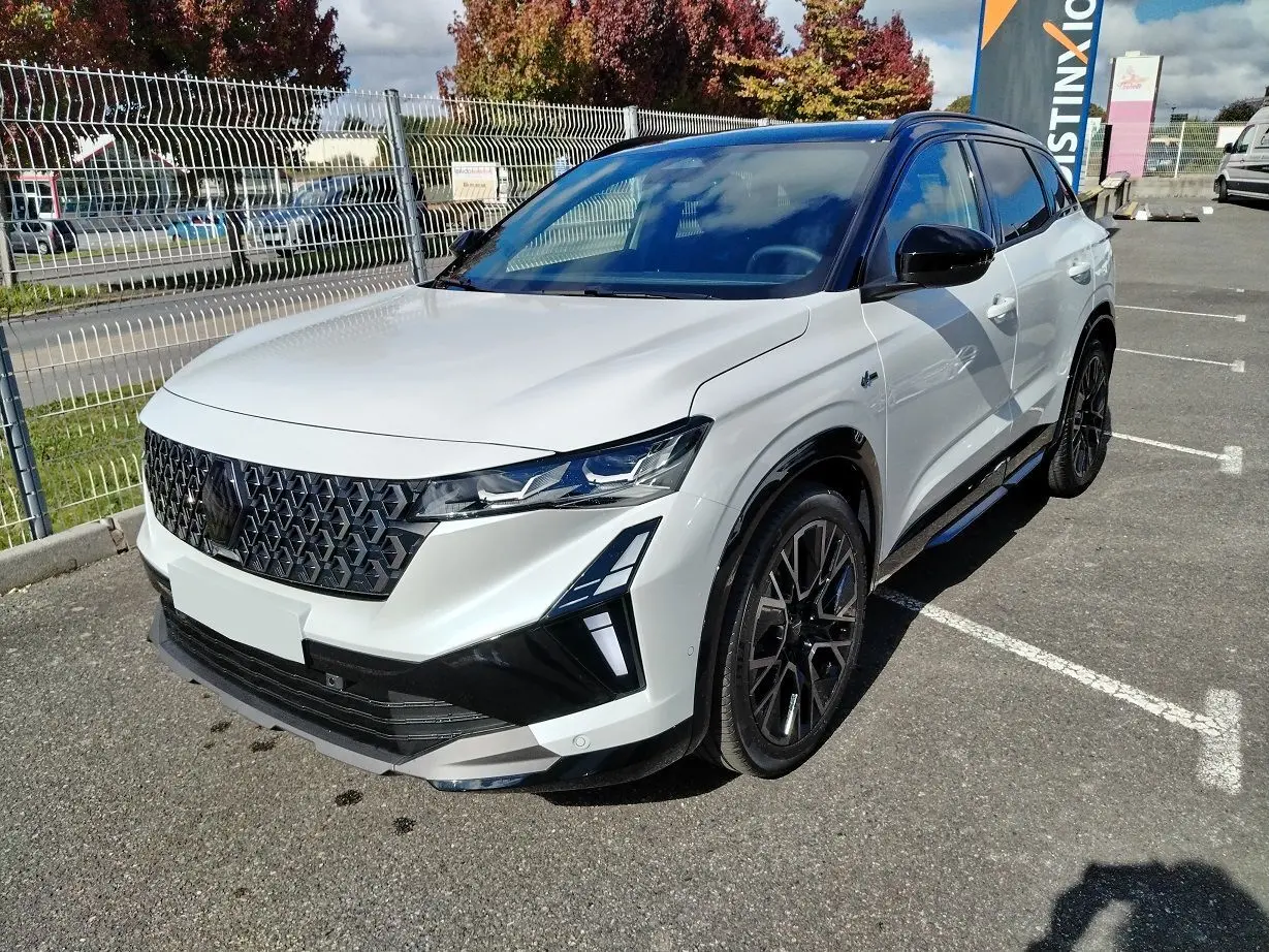 Renault Austral E-Tech blanc nacré avec toit noir, vue 3/4 avant droit, calandre et jantes noires distinctives.