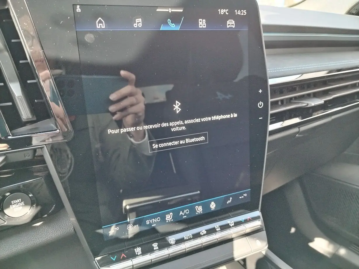 Écran tactile central du tableau de bord du Renault Austral blanc nacré, avec commandes climatisation et bouton start visible.