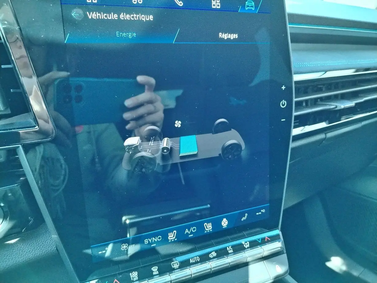 Écran tactile central du Renault Austral E-Tech blanc nacré, affichant la gestion énergétique du véhicule hybride.