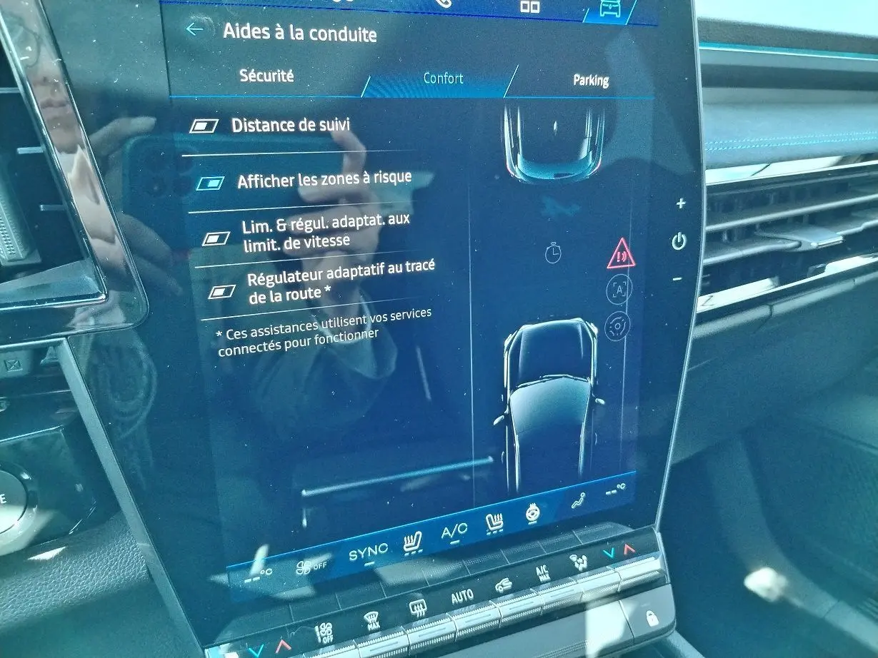 Écran tactile central du Renault Austral E-Tech blanc nacré, affichant les aides à la conduite et la climatisation.