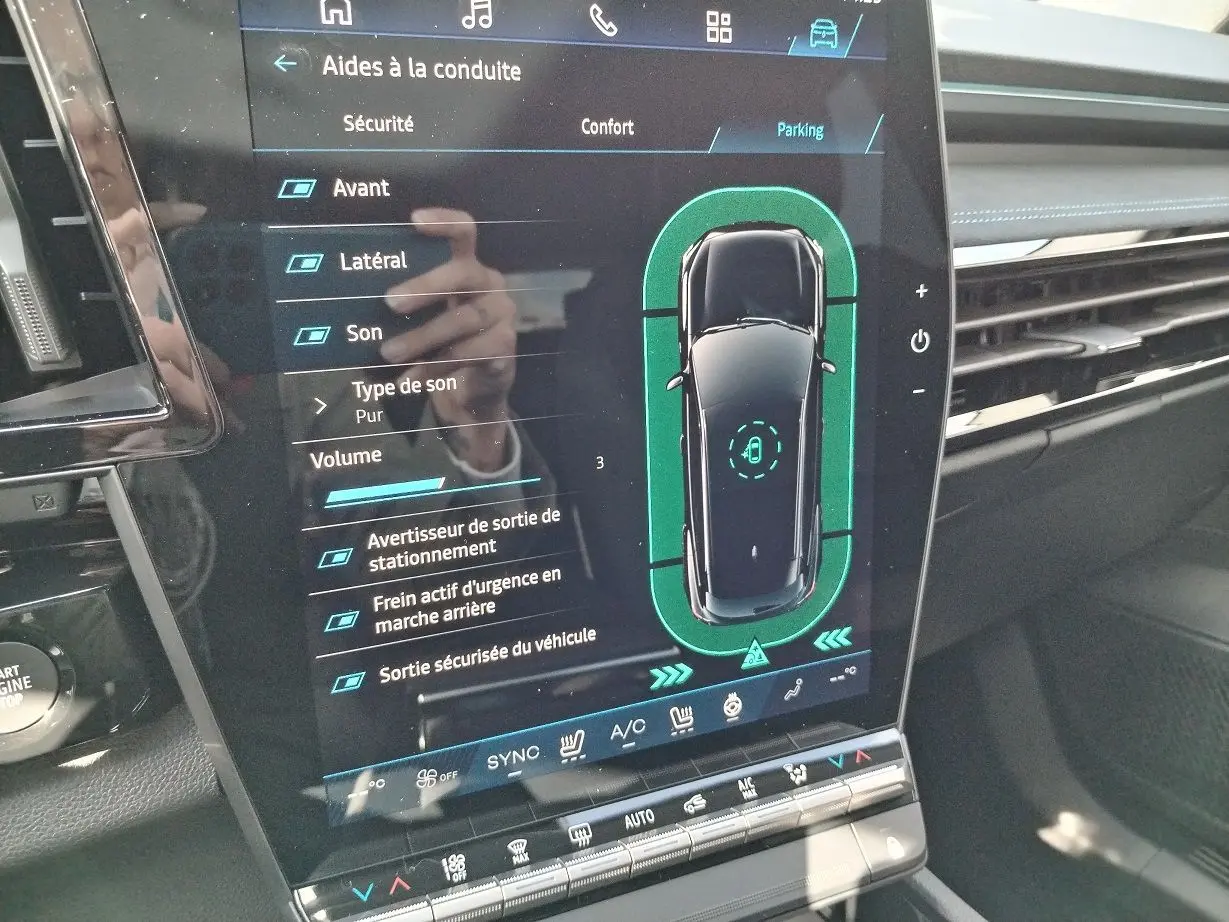 Écran tactile intérieur du Renault Austral E-Tech blanc nacré, affichant les aides à la conduite en mode parking.