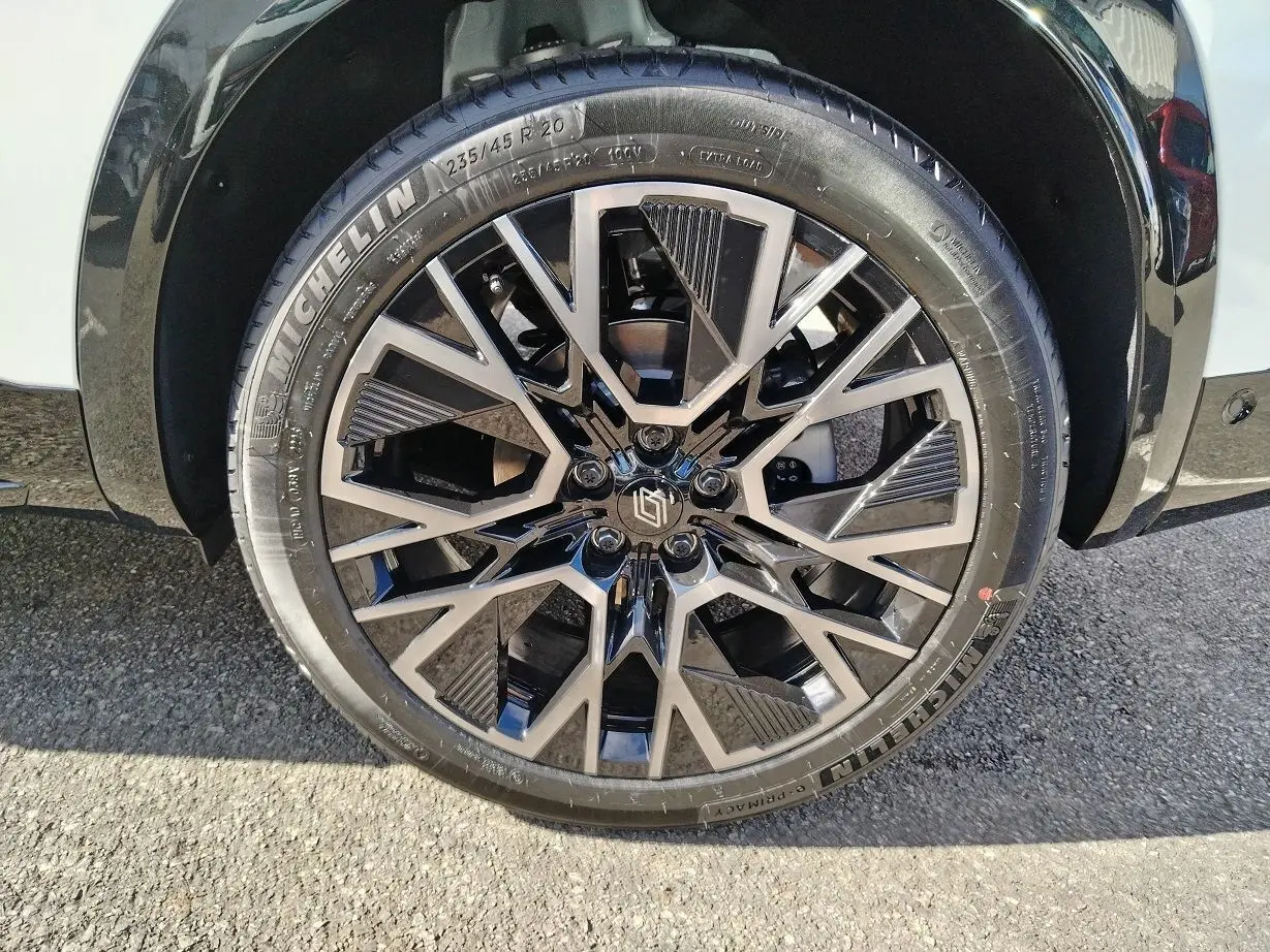 Gros plan sur la jante noire et argentée du Renault Austral blanc nacré avec pneu Michelin, côté avant droit.