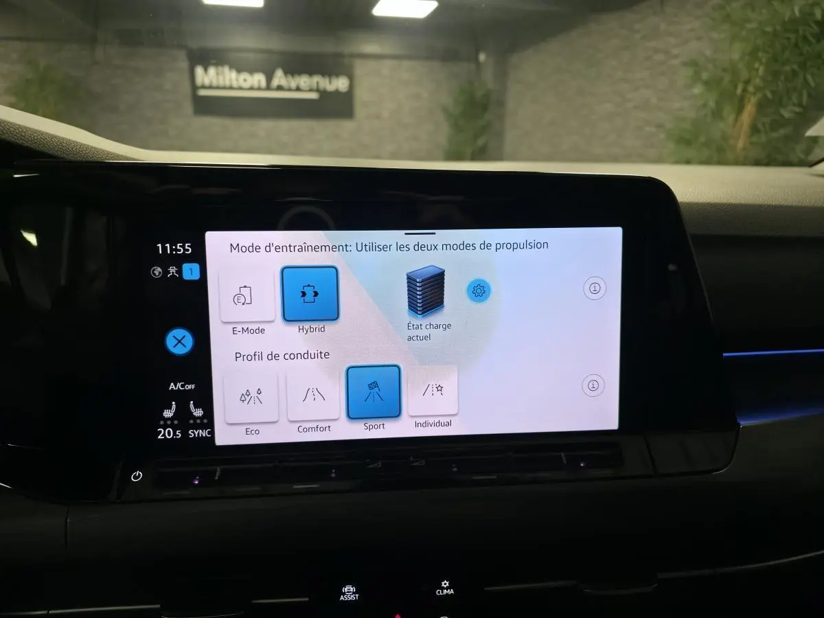 Écran tactile du tableau de bord de la Volkswagen Golf 1.4 eHybrid affichant les modes de conduite et propulsion hybride.