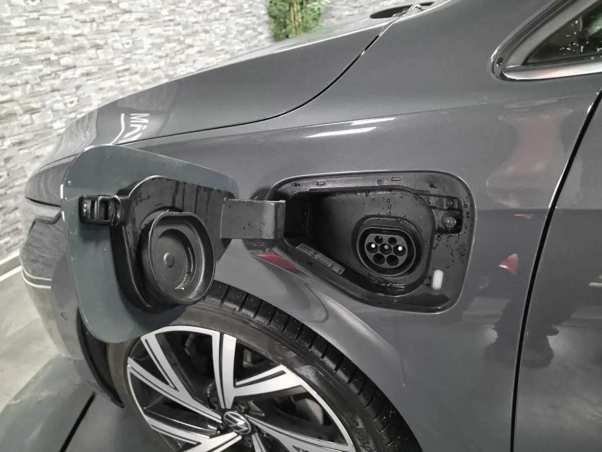 Prise de recharge ouverte côté avant gauche sur Volkswagen Golf gris avec jante alliage 18 pouces visible.