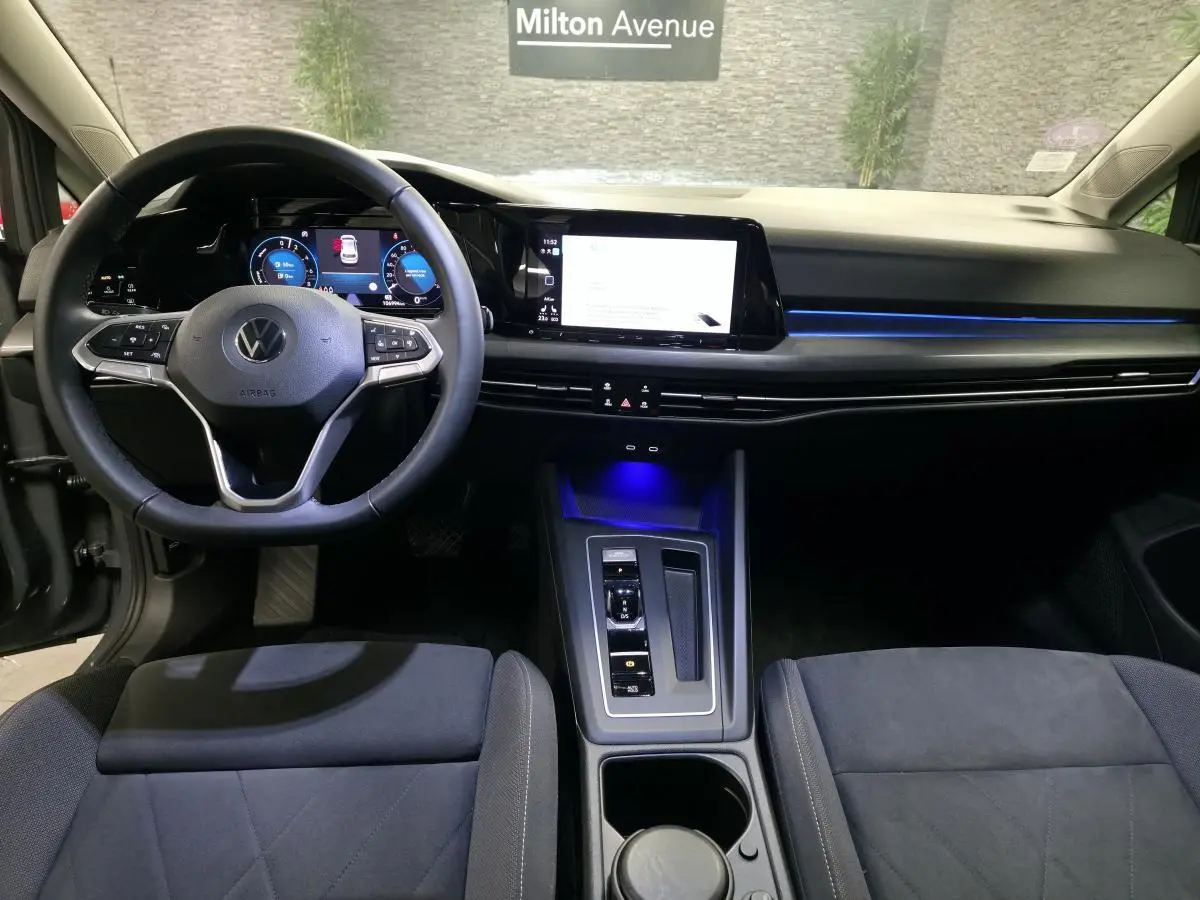 Intérieur avant de la Volkswagen Golf 1.4 eHybrid 2020, tableau de bord moderne avec éclairage bleu et volant multifonction.