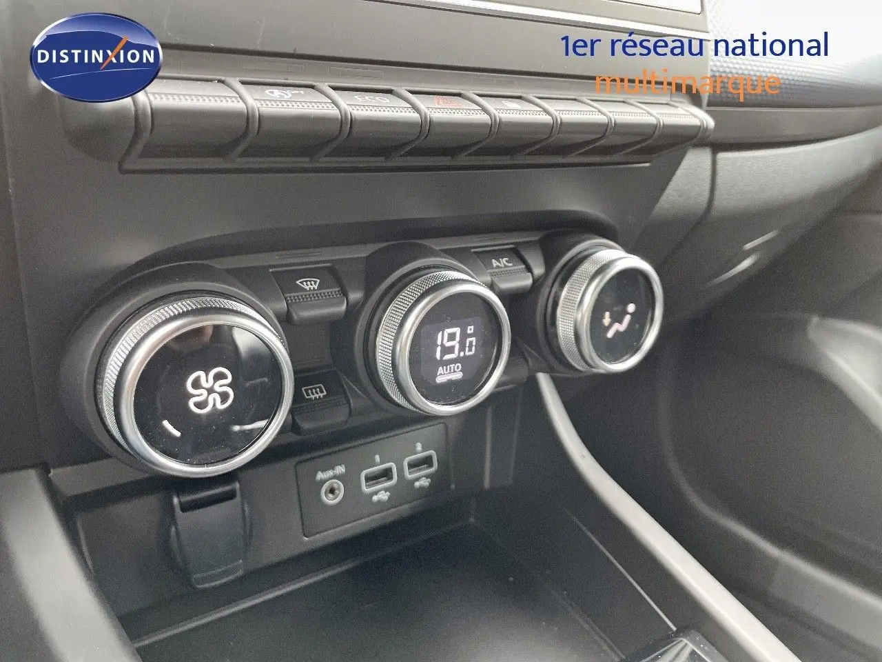 Gros plan sur la console centrale du Renault Arkana noir 2023, montrant les commandes de climatisation et ports USB.