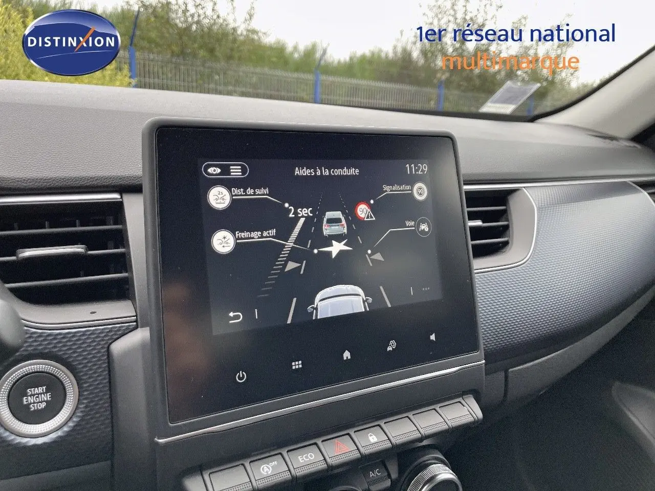 Vue intérieure centrée sur l'écran tactile du tableau de bord du Renault Arkana noir, affichant l'aide à la conduite.