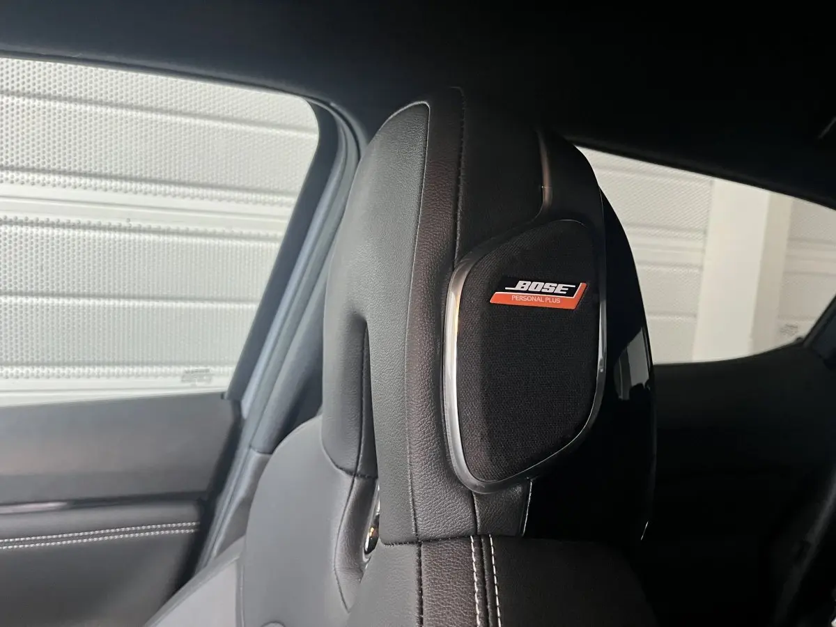 Gros plan sur l’appuie-tête en cuir noir avec haut-parleur Bose intégré dans un Nissan Juke Hybrid 2024.