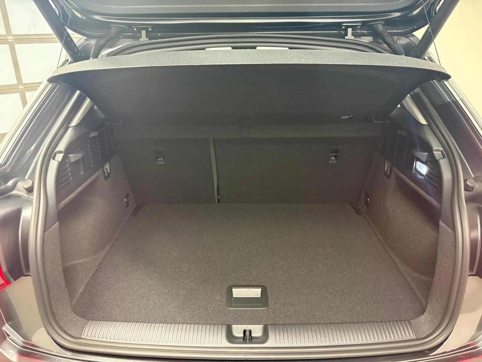 Coffre ouvert vu de l'arrière d'un Audi Q2 35 TFSI S Line gris Daytona avec habillage intérieur noir.
