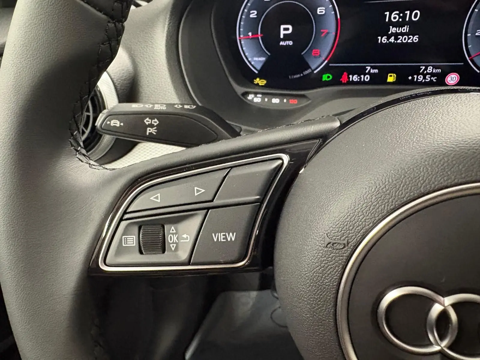 Gros plan sur les commandes gauche du volant et le tableau de bord numérique d’un Audi Q2 35 TFSI 2026.