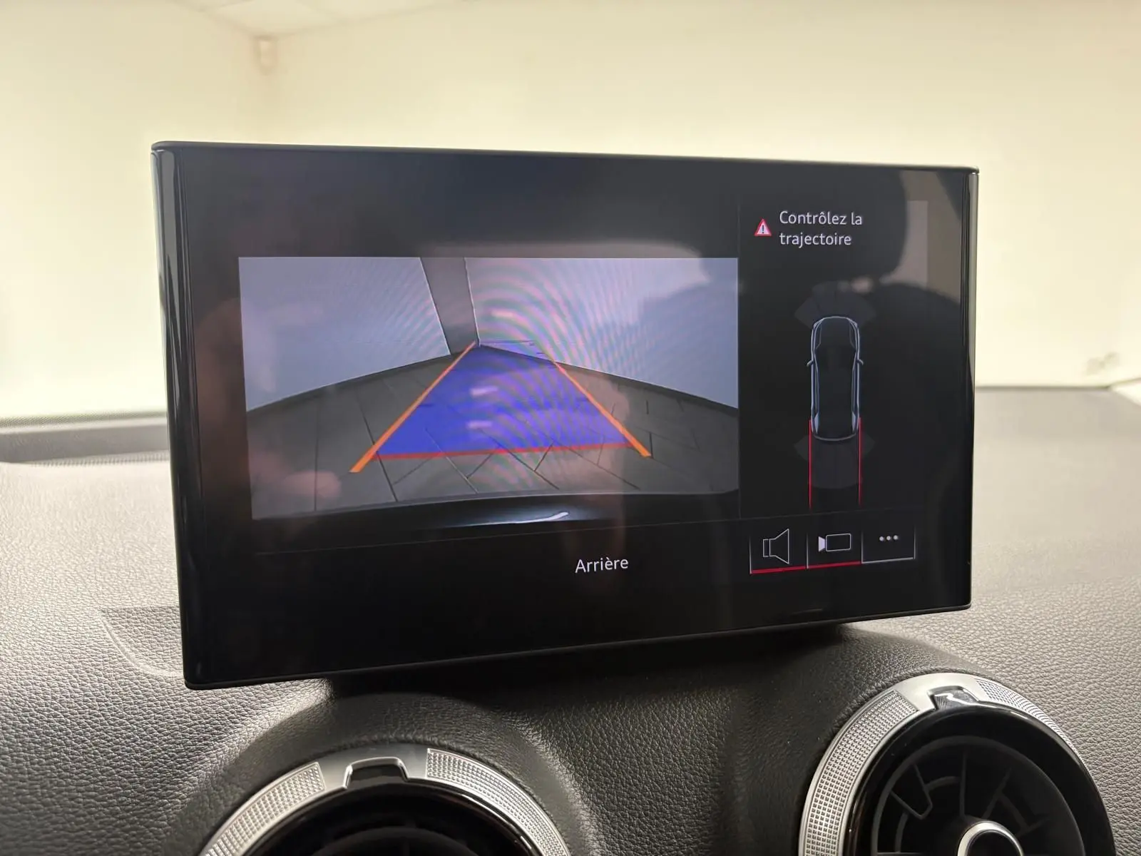 Écran intérieur montrant la caméra de recul et l'alerte de trajectoire de l'Audi Q2 Gris Daytona, version 2026.
