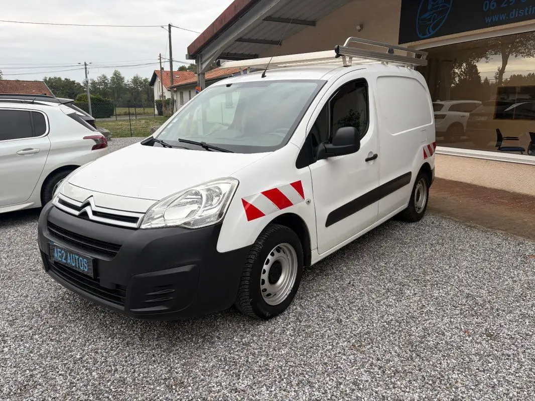 Vue 3/4 avant droit d'un Citroën Berlingo blanc fourgon 2018 avec bandes réfléchissantes rouges sur ailes et galerie de toit.