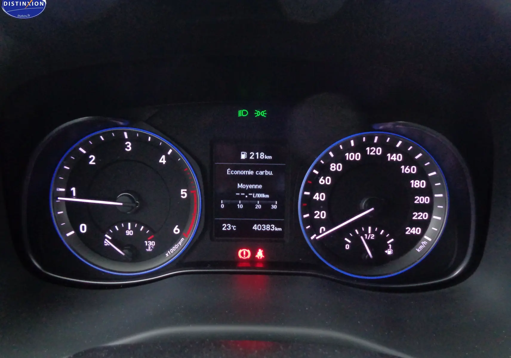 Tableau de bord du Hyundai Kona 2019 avec compte-tours, compteur de vitesse et écran central affichant consommation et autonomie.