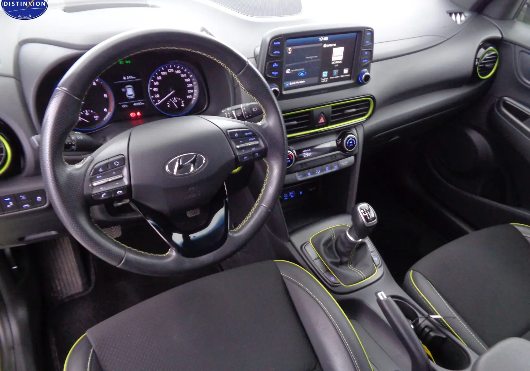Intérieur du Hyundai Kona 2019 en vue avant, volant cuir noir avec surpiqûres jaunes et console centrale avec écran tactile.
