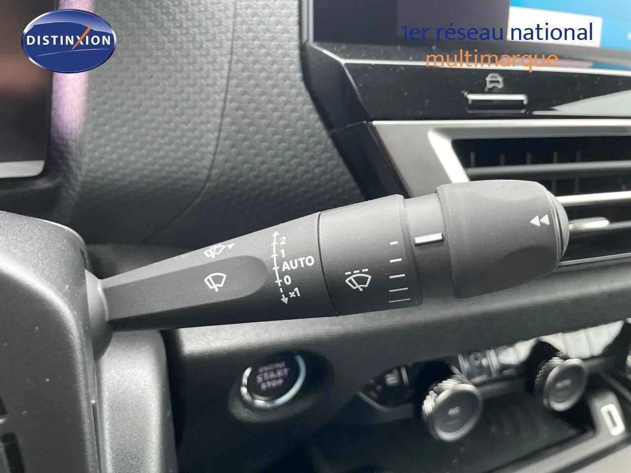 Gros plan sur la commande des essuie-glaces dans l'habitacle d'une Citroën C4 blanche métal 2024.