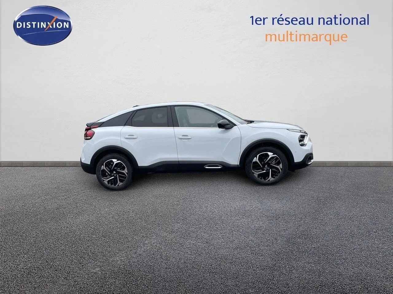 Profil droit d'une Citroën C4 blanche métal 2024 avec jantes noires et toit noir contrasté sur fond neutre.